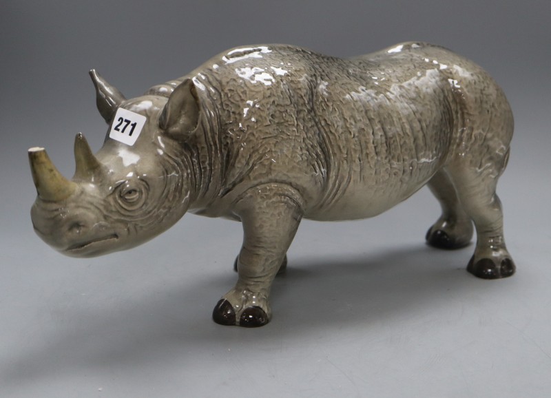 A Melba ware porcelain rhinoceros, height 20cm (a.f.), the broken end of horn is present
